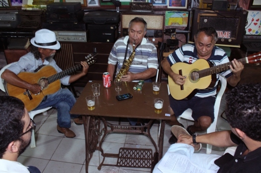 Ladeados pelos chororrepórteres, Os Irmãos Gomes. Da esquerda para a direita: Bastico (violão), Zequinha do Sax e Biné do Cavaco (violão). Foto: Murilo Santos